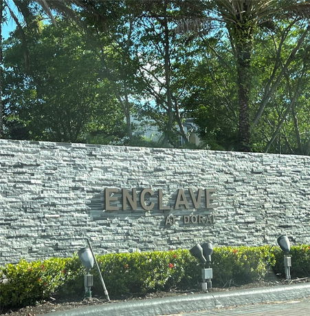 Front view of a stone wall with the text 'ENCLAVE AT DORAL'.