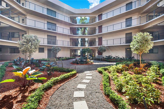 Courtyard view of a multi-story building with balconies and landscaped gardens.