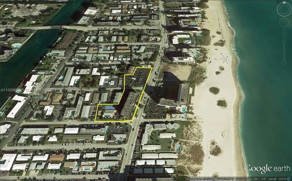 Aerial view of a residential area near a beach, showing a mix of buildings and roads.