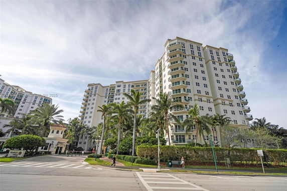 Front view of a multi-story residential building with numerous balconies.