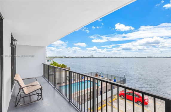 Balcony view overlooking a body of water with a distant city skyline.