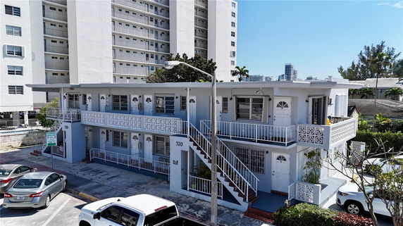 Front view of a two-story residential building with exterior staircases and decorative railing.