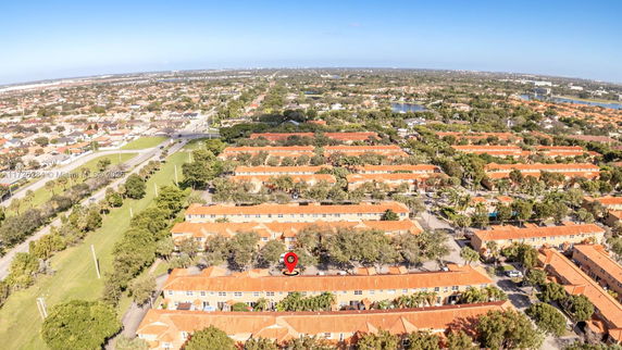 Panoramic aerial view of a residential area with rows of houses and orange roofs.