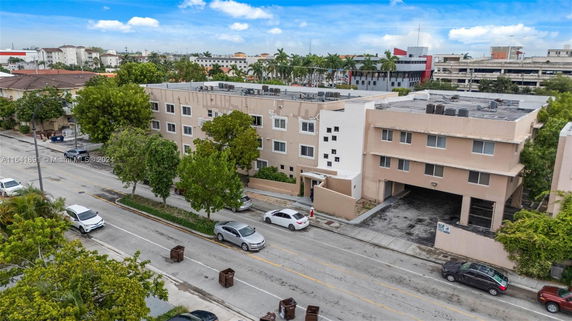 Front view of a multi-story apartment building with a flat roof and multiple windows.