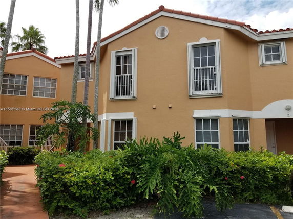Front view of a two-story house with large windows and a terracotta roof.