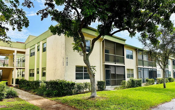 Front view of a two-story apartment building with balconies and green trim
