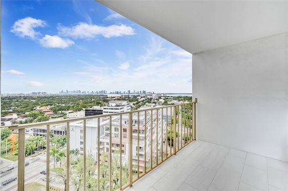Balcony view overlooking a cityscape with buildings and a distant skyline.