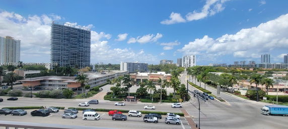 View of a cityscape featuring tall residential and commercial buildings with streets and traffic.