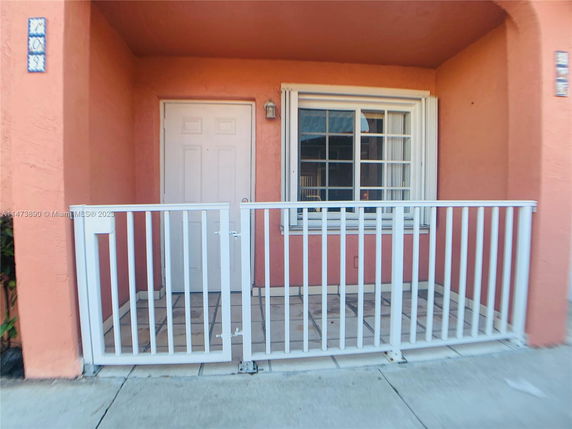 Front view of a house with a small fenced patio.
