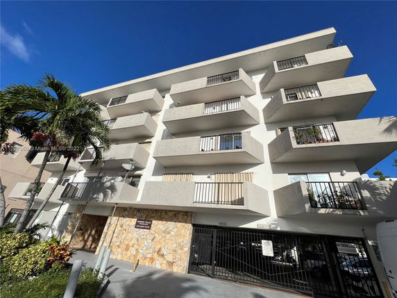 Front view of a multi-story apartment building with balconies.