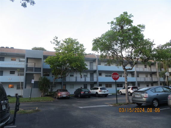 Front view of a multi-story residential building with multiple balconies.