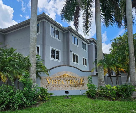 Front view of a multi-story condominium building with signage in front.