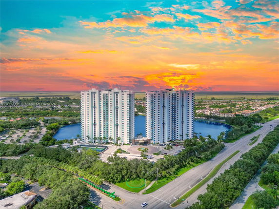 Front view of tall residential buildings with a sunset background.