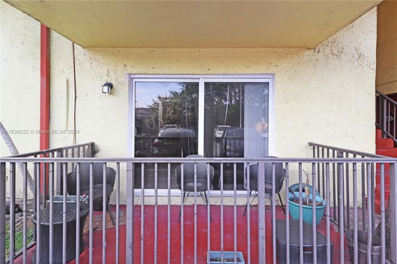 View of a patio area with sliding glass doors and outdoor furniture.