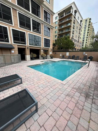 Outdoor swimming pool area next to a multi-story building.
