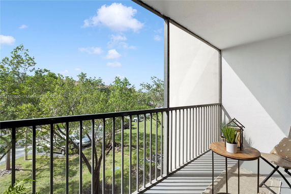 View from a balcony overlooking trees and open sky.