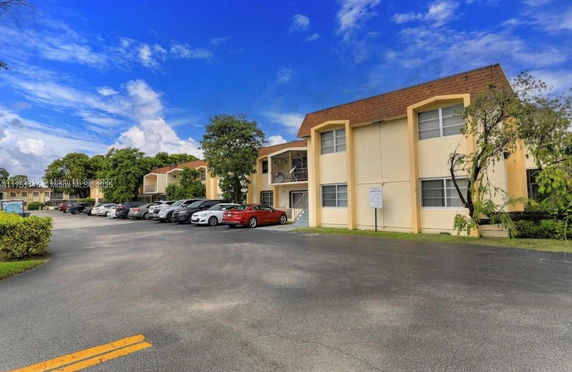 Outdoor parking area in front of a two-story apartment complex.