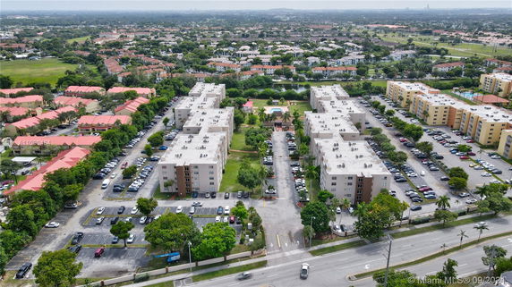 Aerial view of a residential complex with multiple apartment buildings and parking areas.