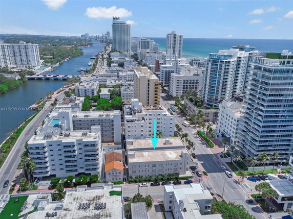 Aerial view of a coastal urban area with several mid-rise and high-rise buildings.