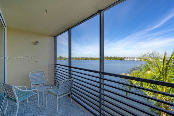Balcony view overlooking a large body of water with distant land.