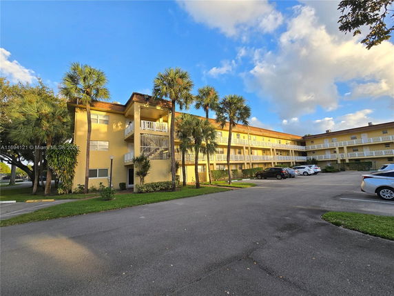 Front view of a three-story apartment building with balconies.