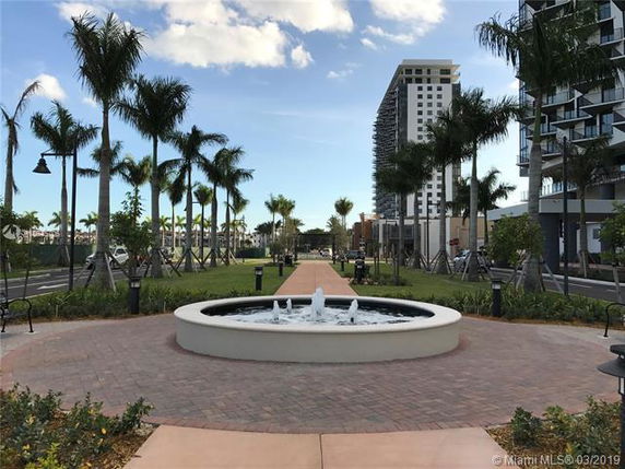 View of surrounding areas with a fountain and palm trees.