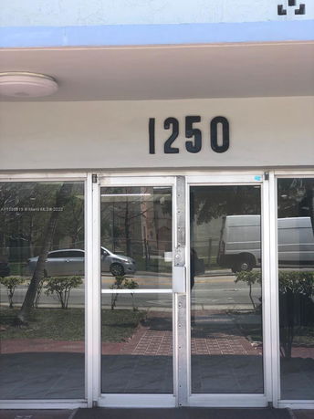 Front view of a building with glass doors and the number 1250 displayed above.