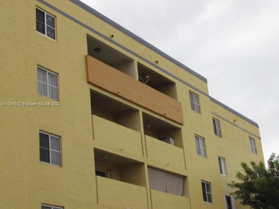 Front view of a multi-story apartment building with balconies.