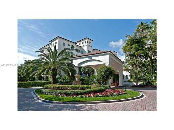 Front view of a multi-story building with an entrance canopy and landscaped driveway.