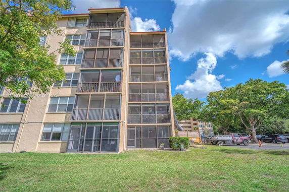 Side view of a multi-story apartment building with screened balconies.