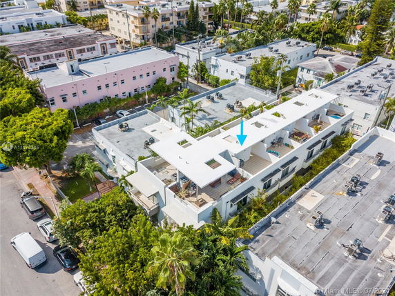 Aerial view of a residential building with multiple rooftops featuring HVAC units and open terraces.