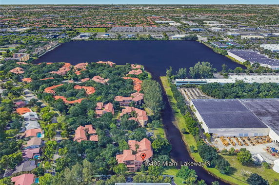 Panoramic view of a residential area surrounded by trees and a large body of water.