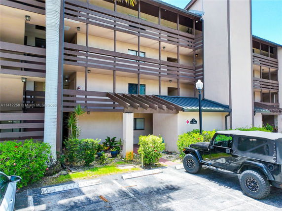 Front view of a multi-story apartment building with balconies.