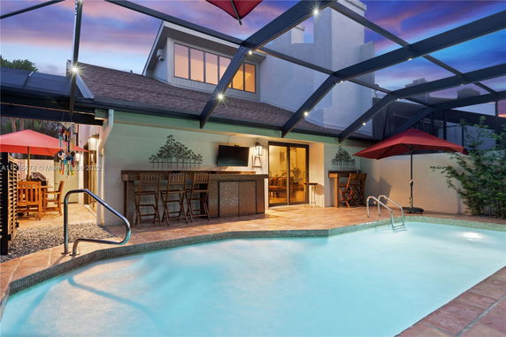 View of a house with a covered patio and swimming pool area.