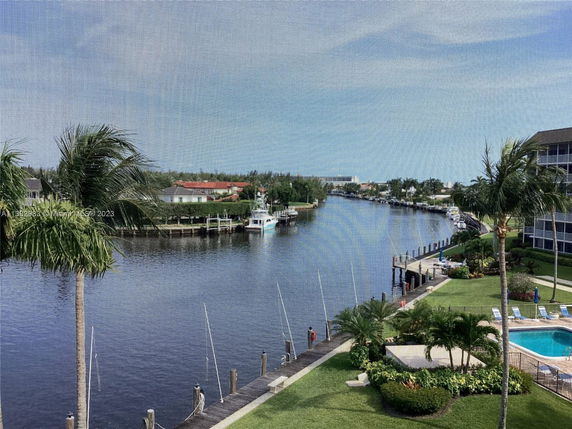 Wide-angle view of a canal with surrounding residential area and swimming pool.