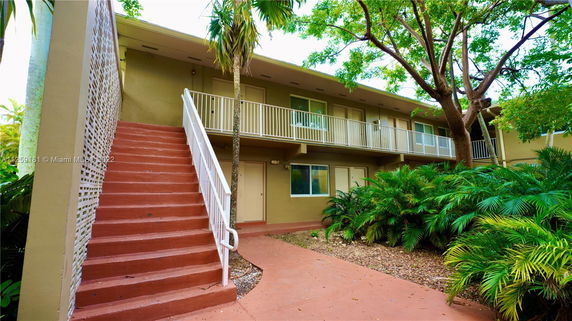 Front view of a two-story building with an exterior staircase.