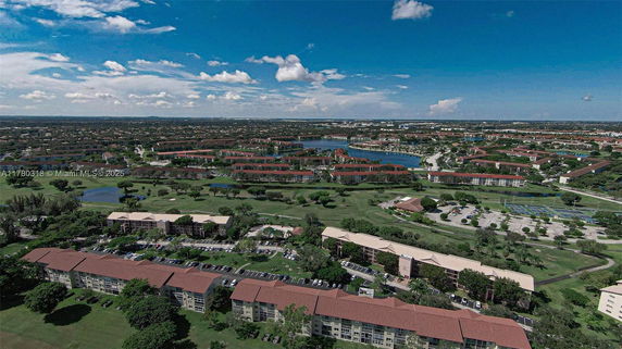 Wide-angle view of residential buildings and landscape with water bodies.