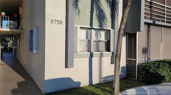 Front view of a building with a window and screen door.