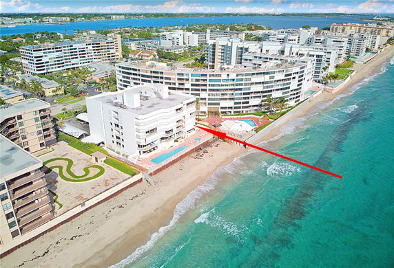 Aerial view of beachfront buildings with surrounding urban landscape.