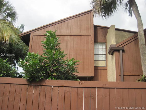 Front view of a multi-story house with wooden siding.