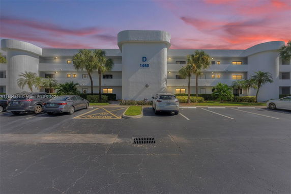 Front view of a multi-story building with a parking area in front.