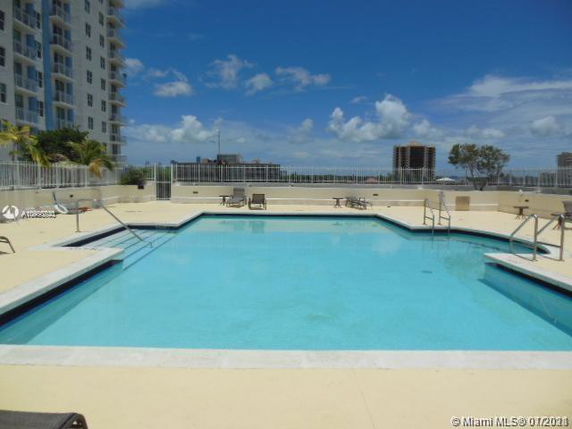 Outdoor swimming pool area surrounded by buildings.