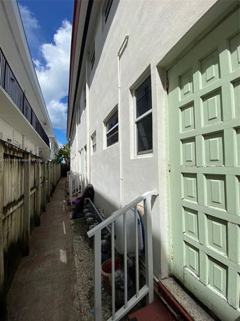 Side view of a multi-story building with narrow pathway.