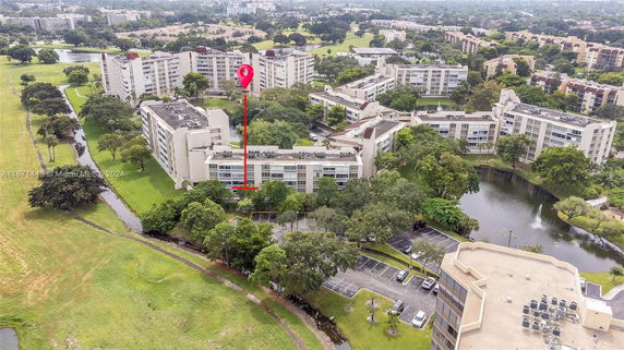 Aerial view of multiple residential buildings surrounded by greenery and water bodies.