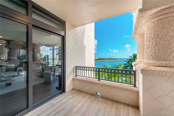 View of a balcony with ornate railing overlooking a body of water and distant landscape.