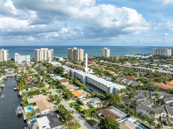 Aerial view of a coastal neighborhood with apartments and houses near the ocean.