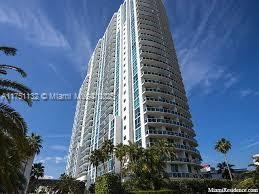 Front view of a tall residential building with multiple balconies.