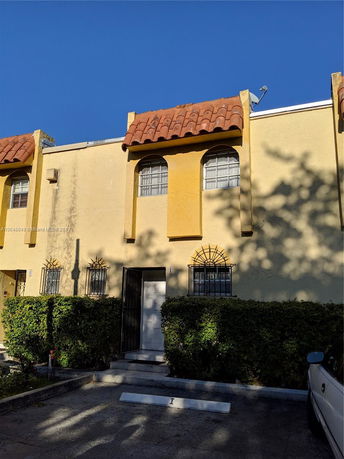 Front view of a two-story house with arched windows and a red-tiled roof.