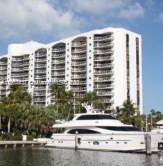 Front view of a multi-story residential building with balconies overlooking the water.