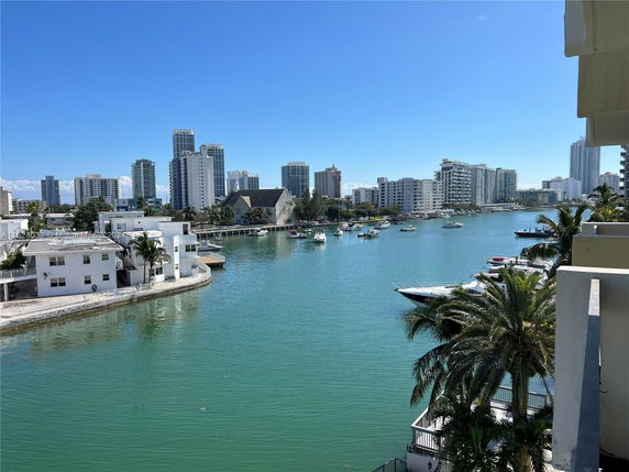 Panoramic view of a waterfront cityscape with boats and high-rise buildings.